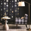 Albany Floor Lamp styled in a dark room with a plaid accent chair. Styled view.