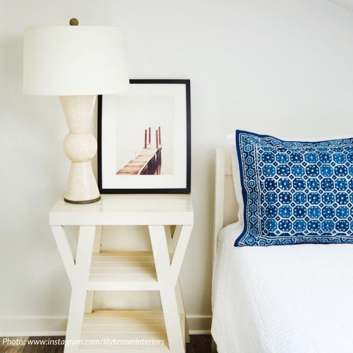 Berkeley Table Lamp styled on a white side table with artwork. Styled view.