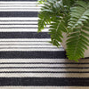 Birmingham Black Indoor/Outdoor Rug styled under a plant. Styled view.