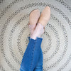 Bowline Natural Indoor/Outdoor Round Rug styled under legs. Styled view.
