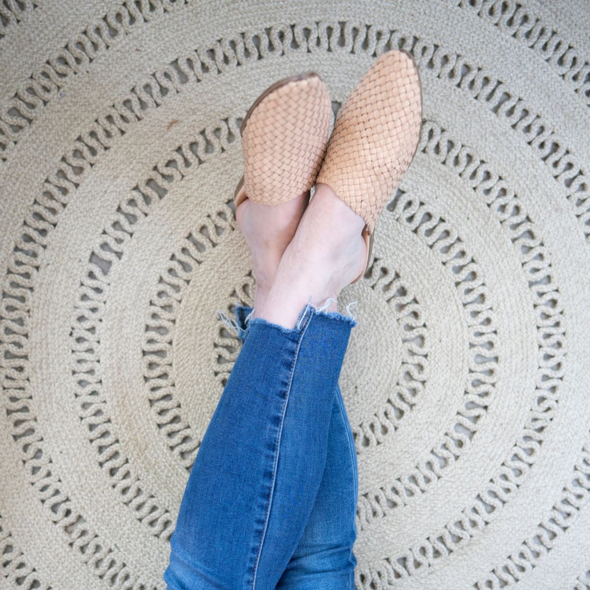 Bowline Natural Indoor/Outdoor Round Rug styled under legs. Styled view.