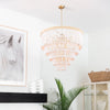 Waterfall Chandelier styled in a white living room beside a fireplace. Styled view.