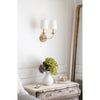 Fisher Double Sconce styled on a white wall above an antique night stand. Styled view.