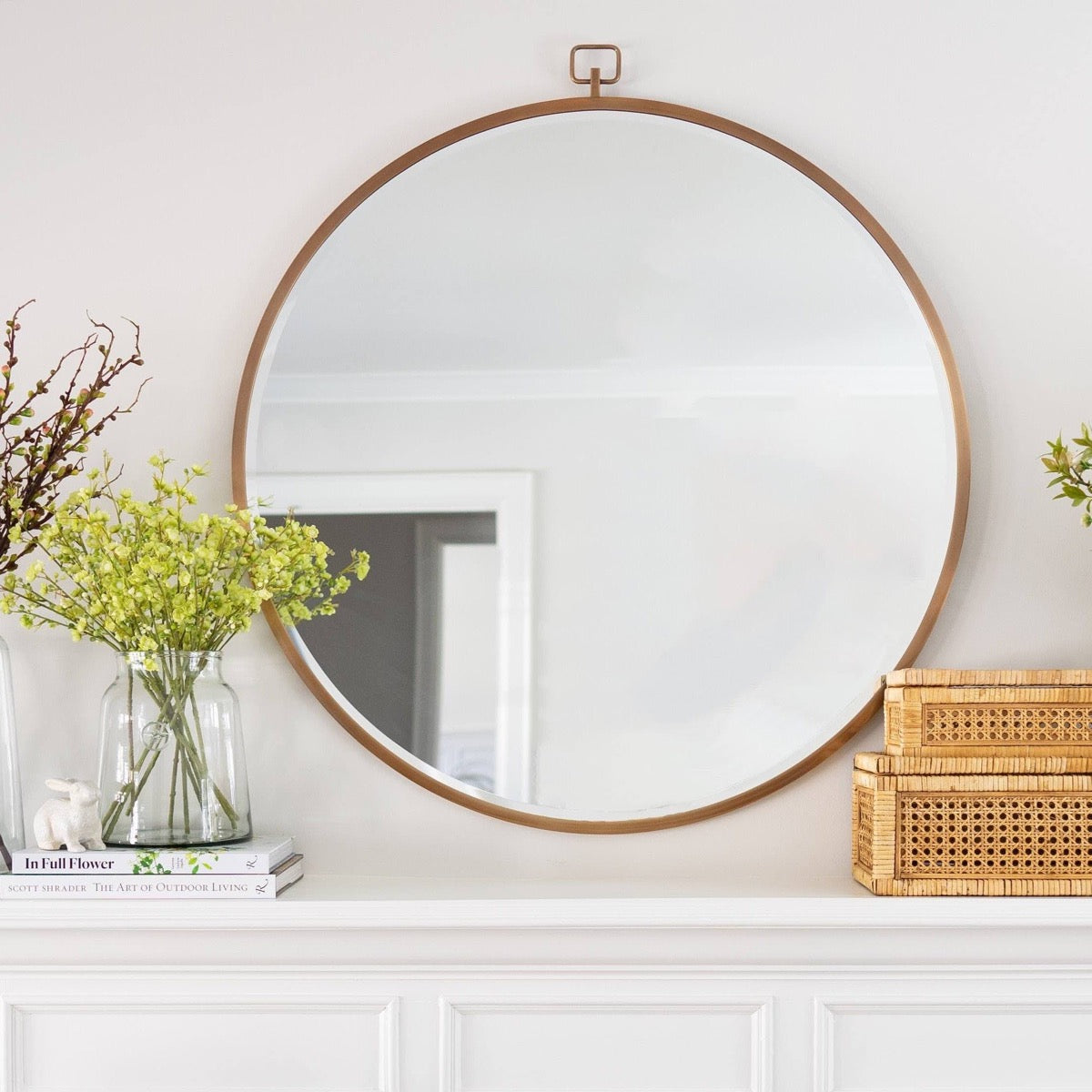 Carrie Mirror styled above a white mantel with decor. Styled view.