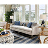 Claire Ceramic Table Lamp styled next to a cream sofa with blue pillows. Styled view.