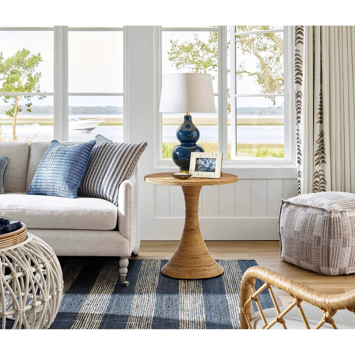 Claire Ceramic Table Lamp styled on a wicker table with sofa and chairs. Styled view.