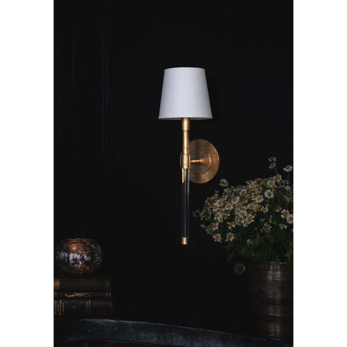Auburn Crystal Sconce styled on a black wall above a dark surface. Styled view.