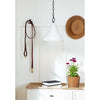 Billie Concrete Pendant - Small styled above a wood console table with books and greenery. Styled view.