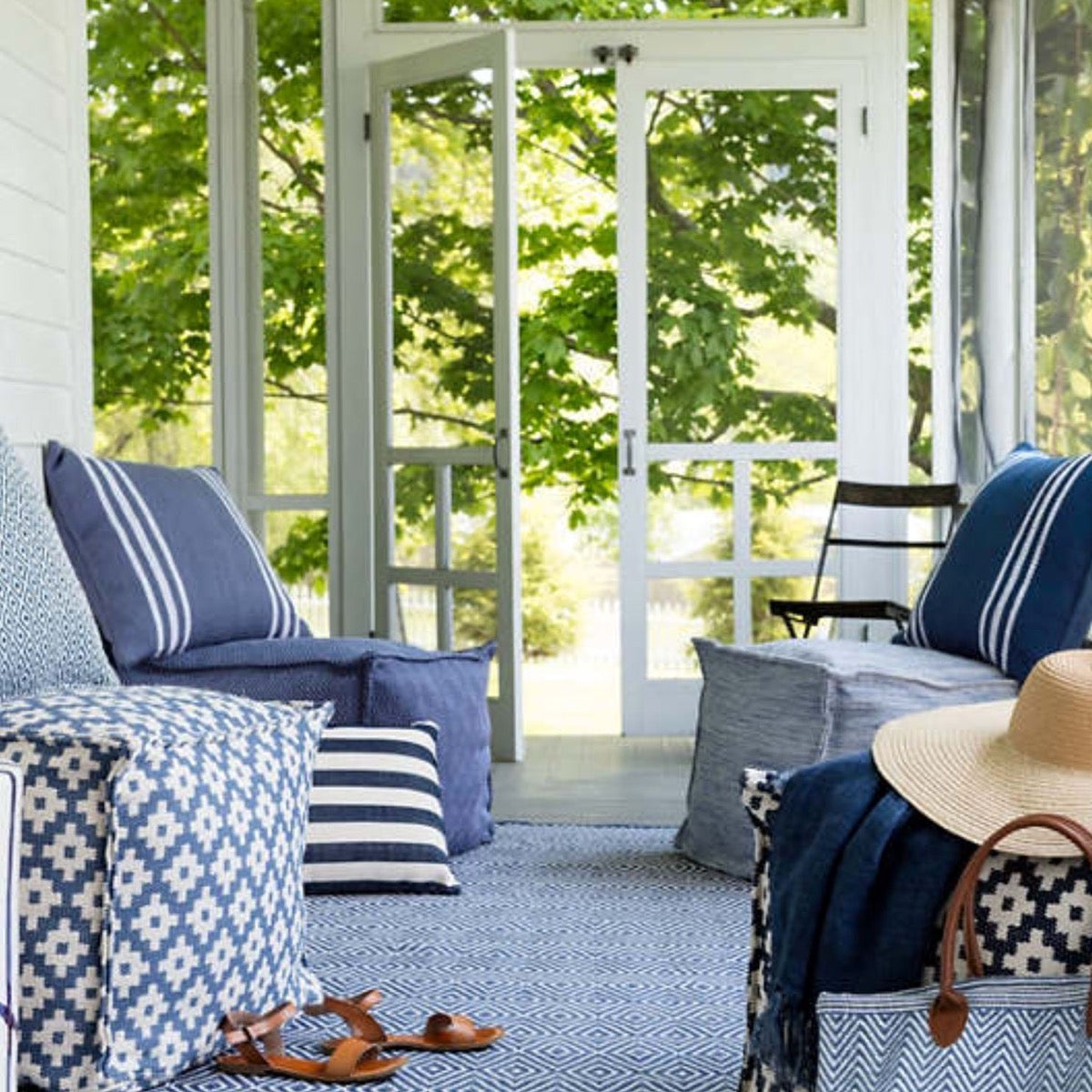 Diamond Denim/White Indoor/Outdoor Rug styled in a blue sunroom. Styled view.