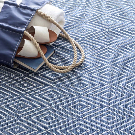 Diamond Denim/White Indoor/Outdoor Rug styled under a blue bag. Styled view.