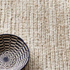 Dunes Bleached Oak Woven Jute Rug styled with a blue bowl. Styled view.