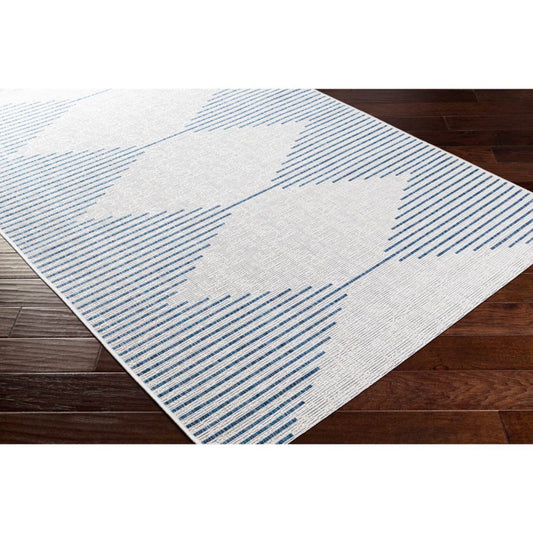 Egan Outdoor Rug styled over dark wood floor. Styled view.