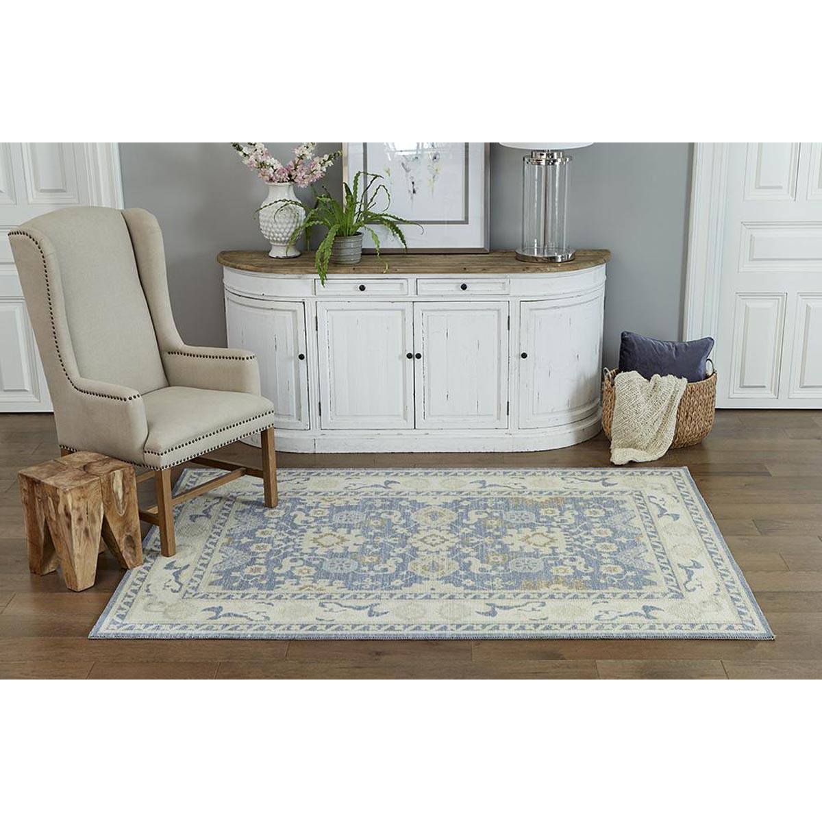 Ellesworth Rug styled with a neutral chair and white console. Styled view.