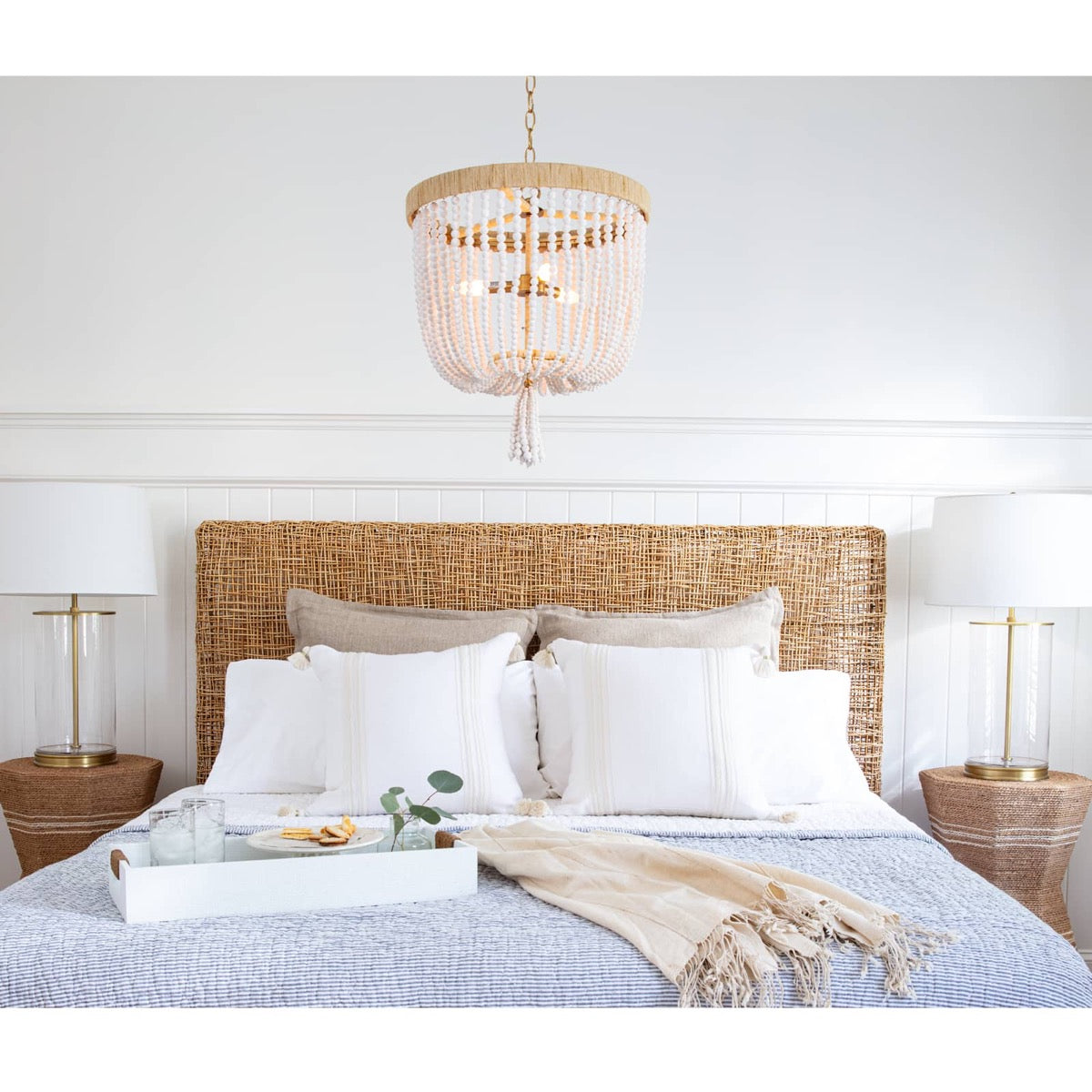 Everly Chandelier styled above a blue bed. Styled view/.