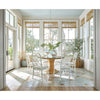 Sail Chandelier styled above a rattan dining table with white chairs in a sunroom. Styled view.