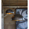Flynn Pendant - Large Black & Gold styled in a rustic barn with blue artwork. Styled view.