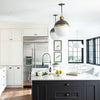 Flynn Pendant - Large White & Gold styled in a white and black itching above white chairs. Styled view.