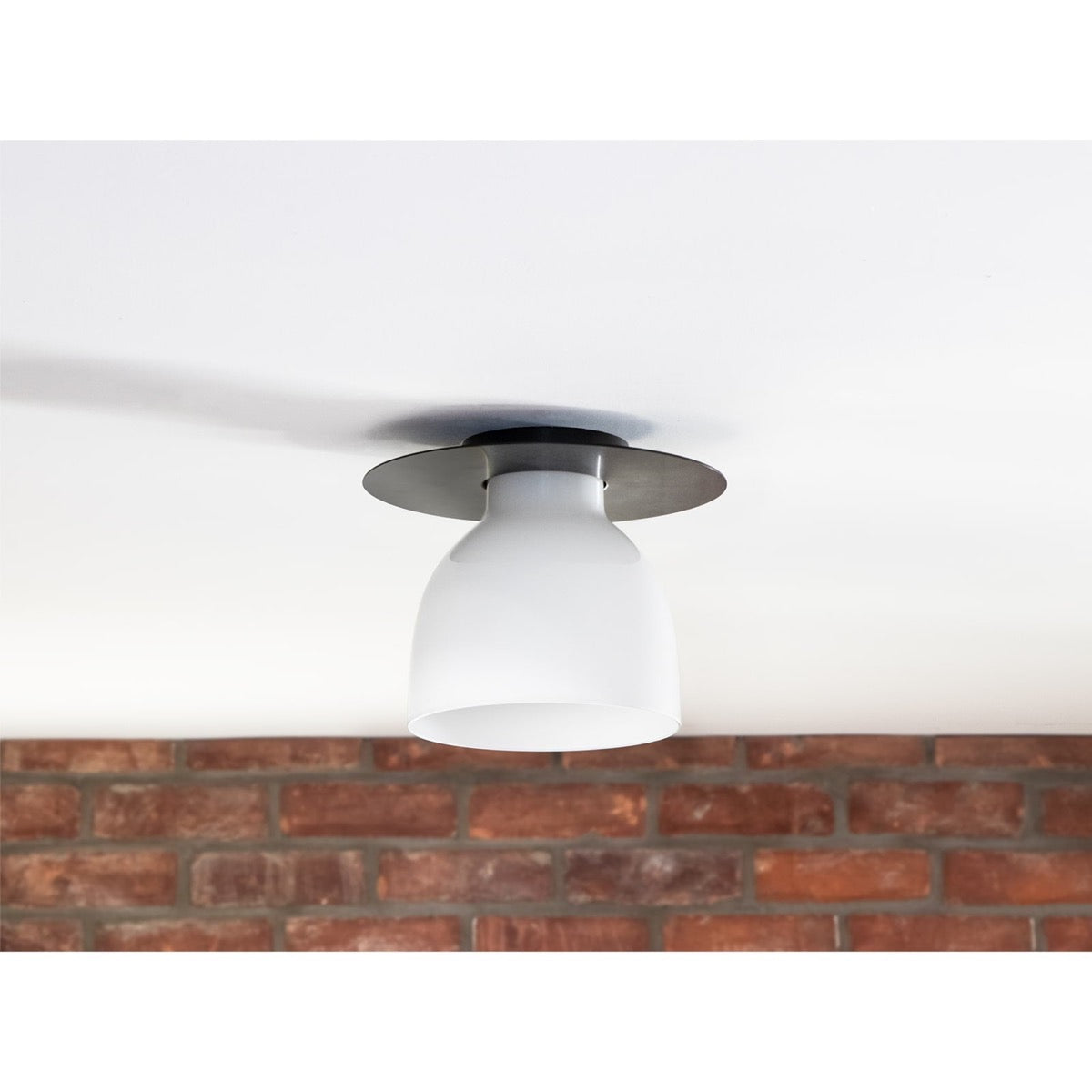 Freya Flush Mount styled against a brick wall. Styled view.