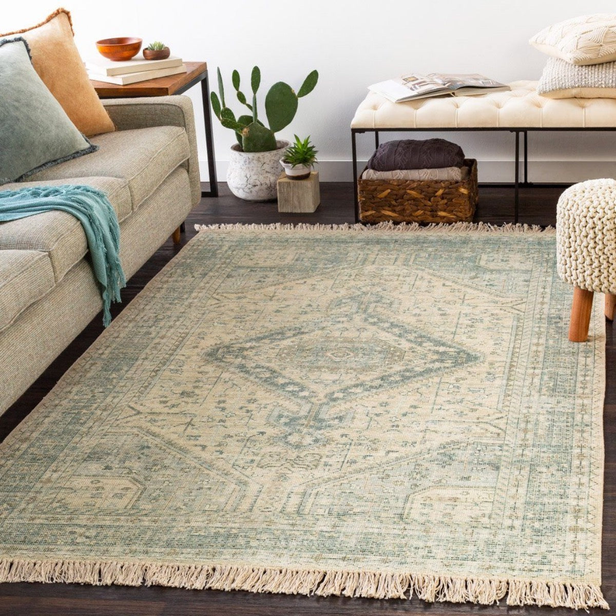 Georgia Rug styled in a neutral living room with throws and greenery. Styled view.