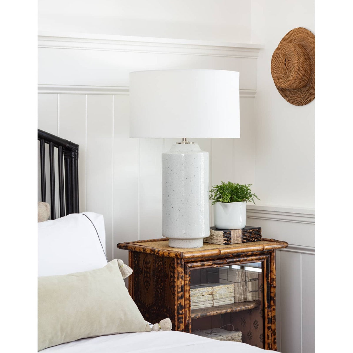 Markus Ceramic Table Lamp styled on a wood table in a white bedroom. Styled view.