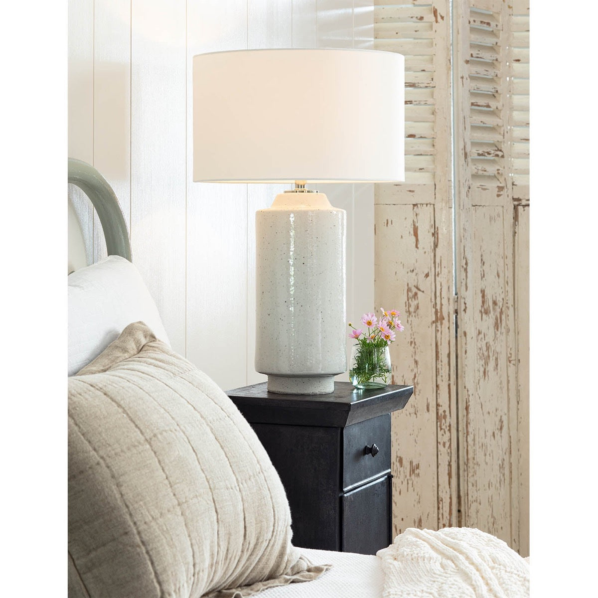 Markus Ceramic Table Lamp styled on a bedside table in a neutral bedroom. Styled view.