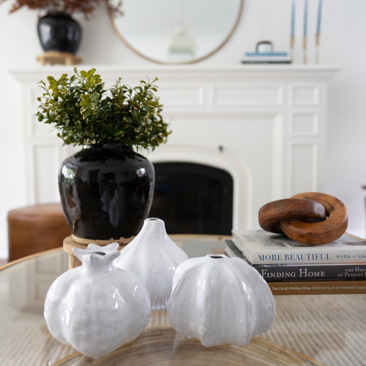 Golden Euonomyous Bush styled in a black jar with white gourds. Styled view.