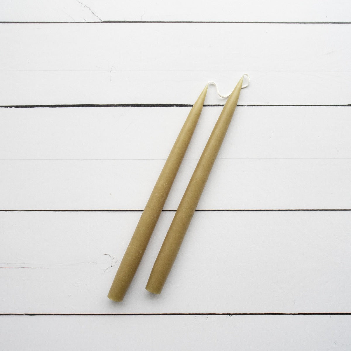 Hand-Dipped Danish Tapers - Olive styled against white wood. Styled view.