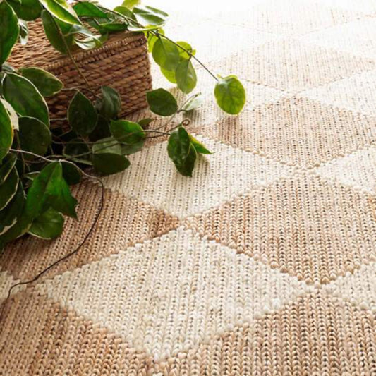 Harwich Natural Woven Jute Rug styled with greenery. Styled view.