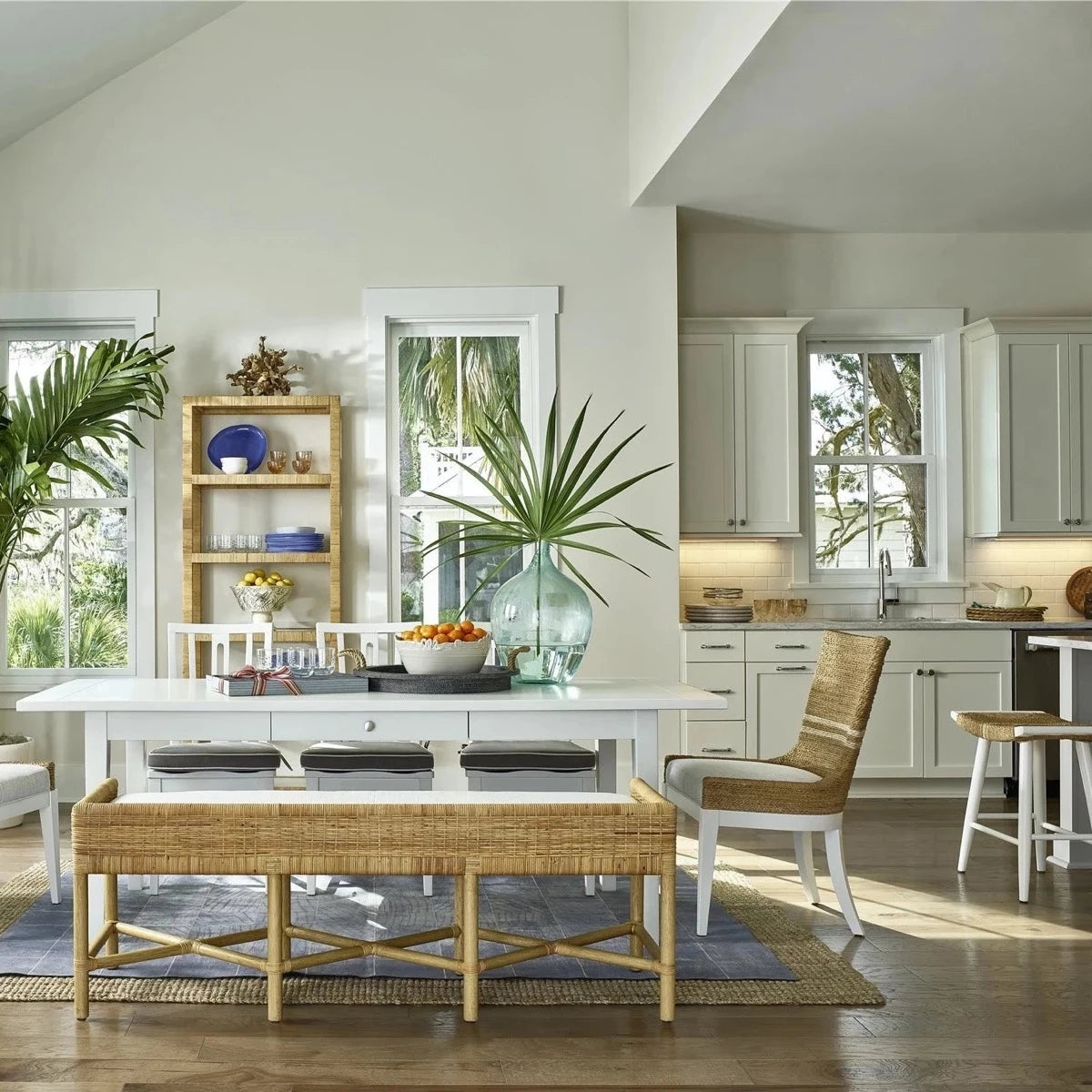 Heidi Bench styled with wicker chairs beside a white kitchen. Styled view.