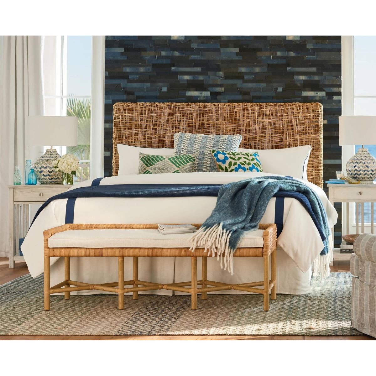 Heidi Bench styled in front of a woven bed with blue accents. Styled view.