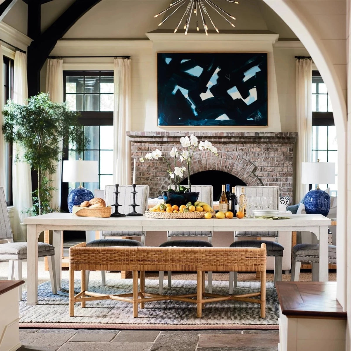 Heidi Bench styled with a white dining table and fireplace. Blue accents surround. Styled view.