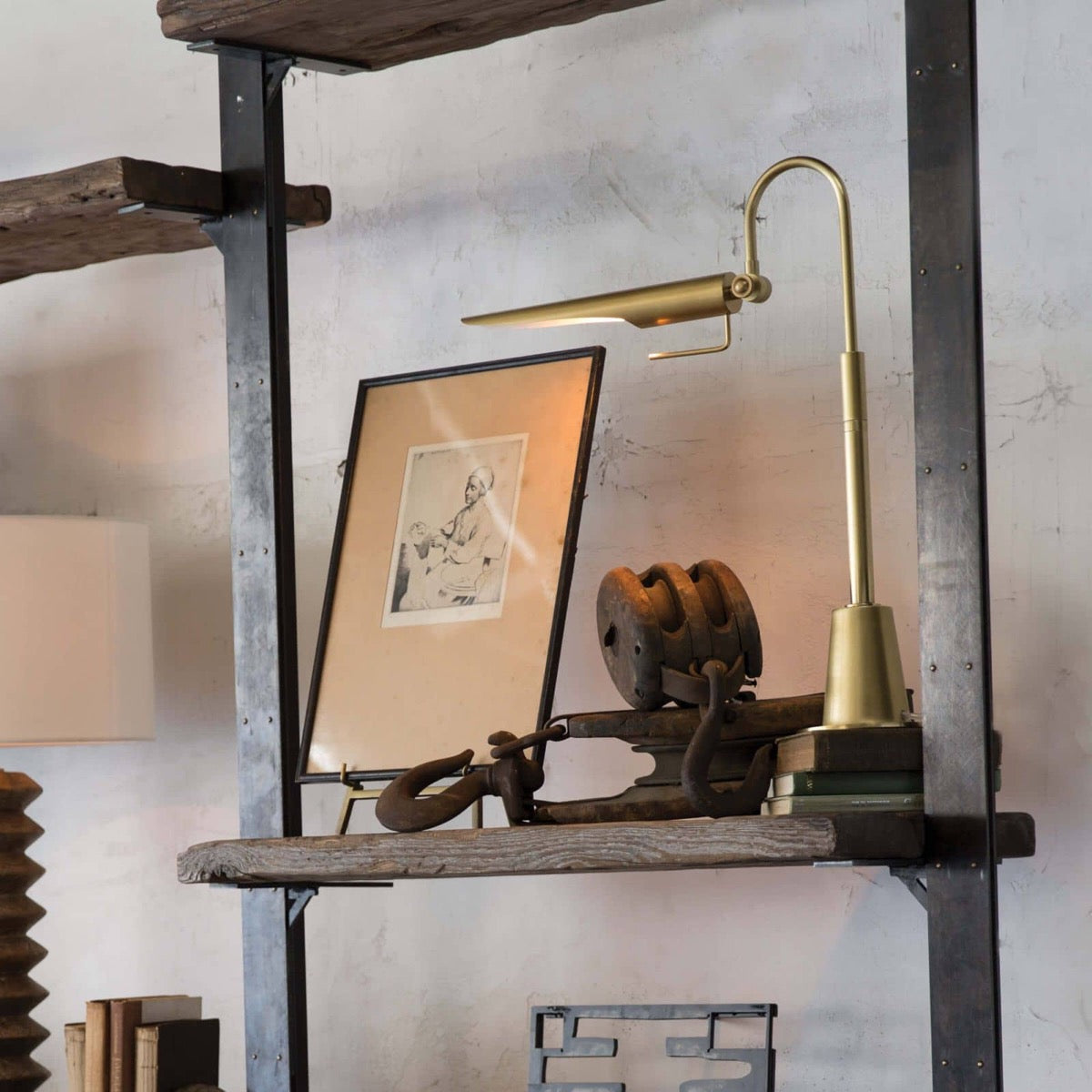 Heron Task Lamp styled on a bookshelf with decor. Styled view.