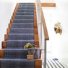 Herringbone Indigo Woven Cotton Rug as a runner on wood stairs. Styled view.