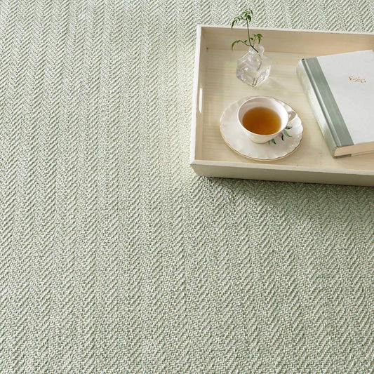 Herringbone Ocean Woven Cotton Rug styled under a wooden tray. Styled view.