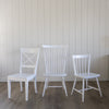 Hooper Dining Chair styled with white chairs. Styled view.