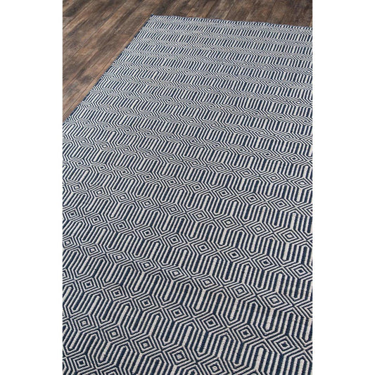 Huron Indoor/Outdoor Rug - Navy over dark wood floor. Styled view.