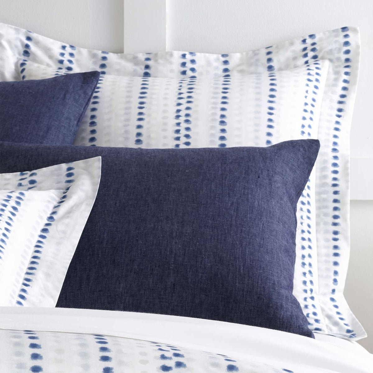 Ink Dots Sham styled with navy sheets. Styled view.