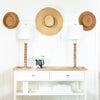 Perennial Buffet Lamp styled on either side of a white console table with decorative hats. Styled view.