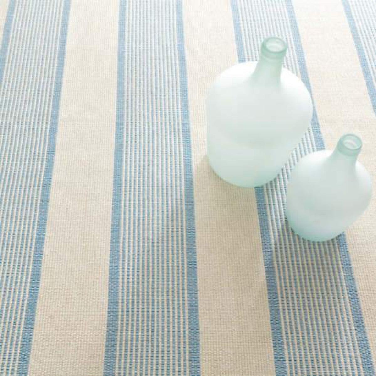 La Mirada Asiatic Blue Woven Cotton Rug styled under blue vases. Styled view.