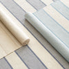 La Mirada Asiatic Blue Woven Cotton Rug styled with striped rugs. Styled view.