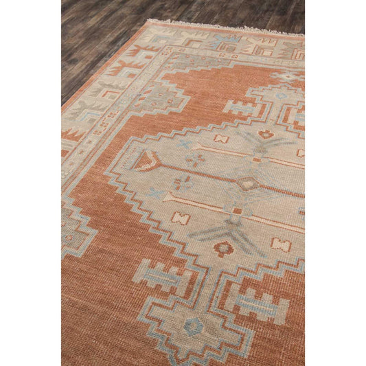 Lily Hand-Knotted Rug - Rust on wood floor. Styled view.