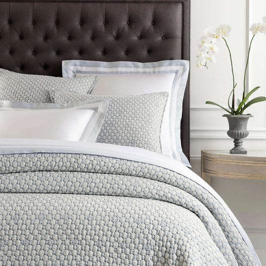 Lodi Blue Matelasse Coverlet styled with grey and white bedding. Styled view.