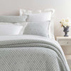 Lodi Silver Matelasse Coverlet styled with white sheets. Styled view.