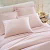 Lush linen bedding in slipper pink. Styled view.