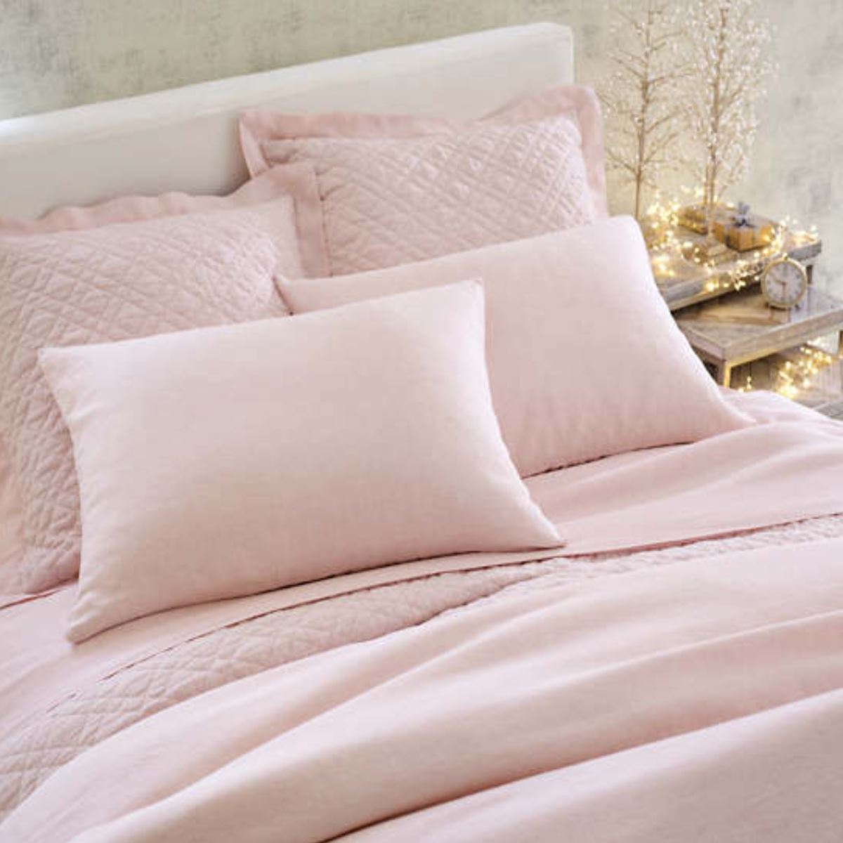 Lush linen bedding in slipper pink. Styled view.