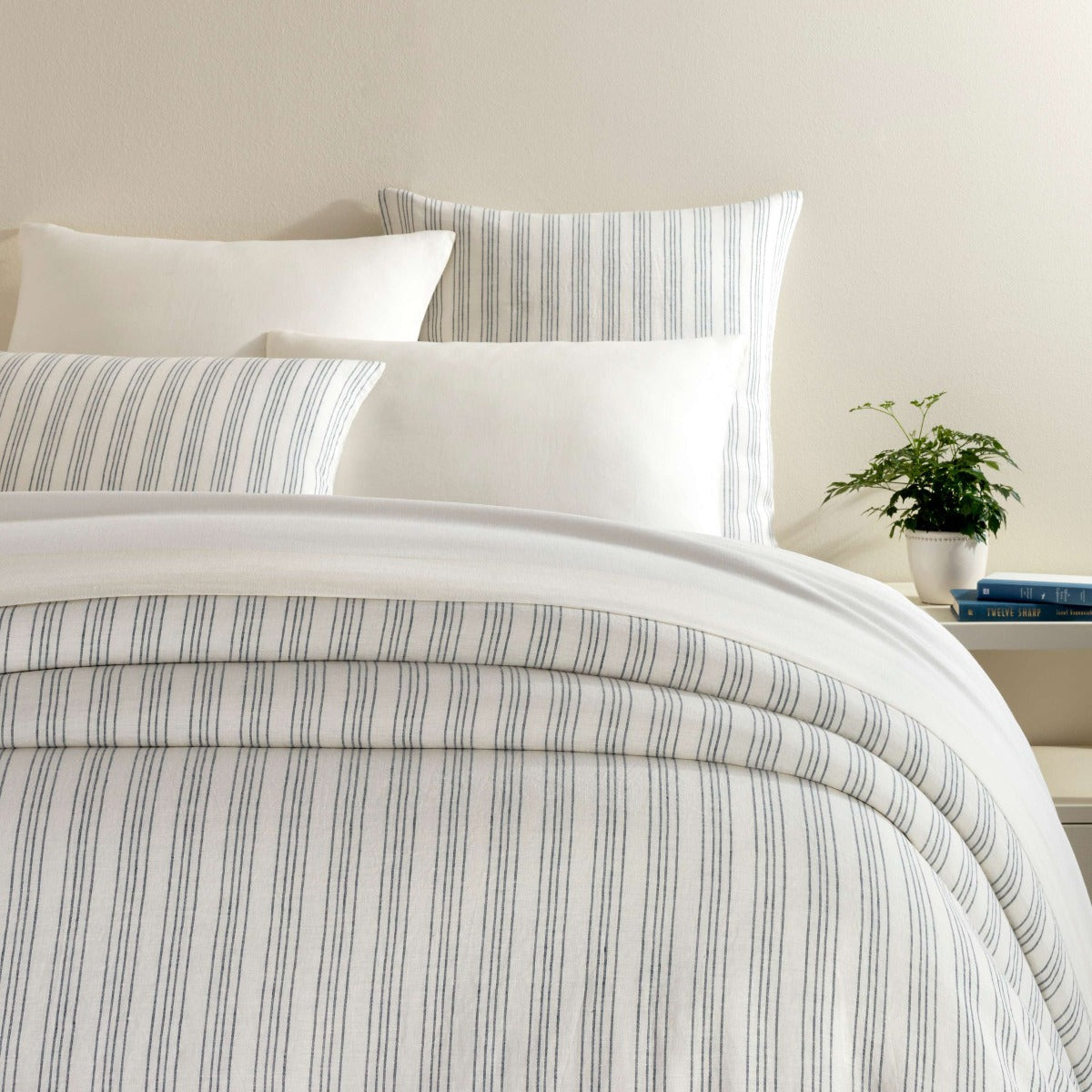 Lush Linen Stripe Slate Blue Duvet Cover styled with white sheets. Styled view. 