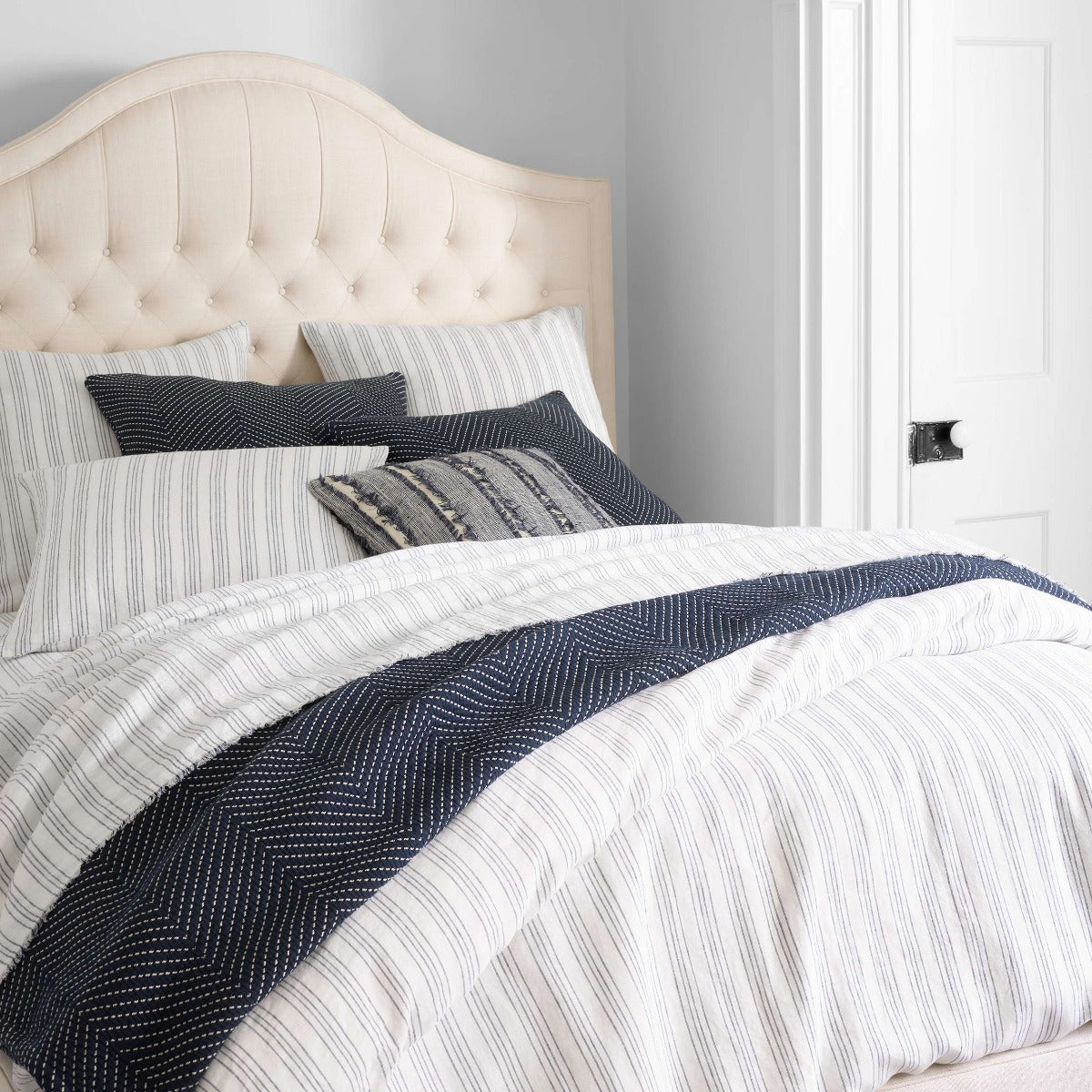 Lush Linen Stripe Slate Blue Duvet Cover styled with navy bedding. Styled view.