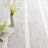 Malta Grey Woven Wool Rug styled under greenery. Styled view.