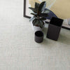 Marled Light Blue Woven Cotton Rug styled under black decor and artwork. Styled view.