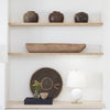 Megan Table Lamp styled on a wood surface with greenery and neutral shelving above. Styled view.
